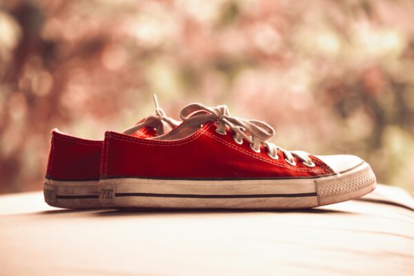 Stylish red canvas sneakers with white laces shown in a classic side view.
