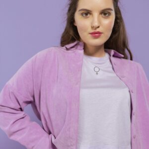 Stylish woman posing in a lavender outfit against a soft background.